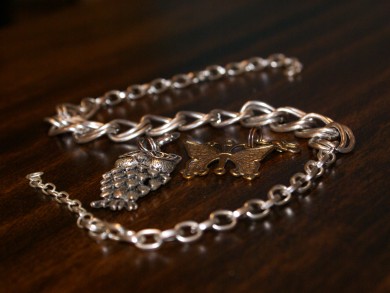 Silver tone necklace with silver tone owl and gold tone butterfly.