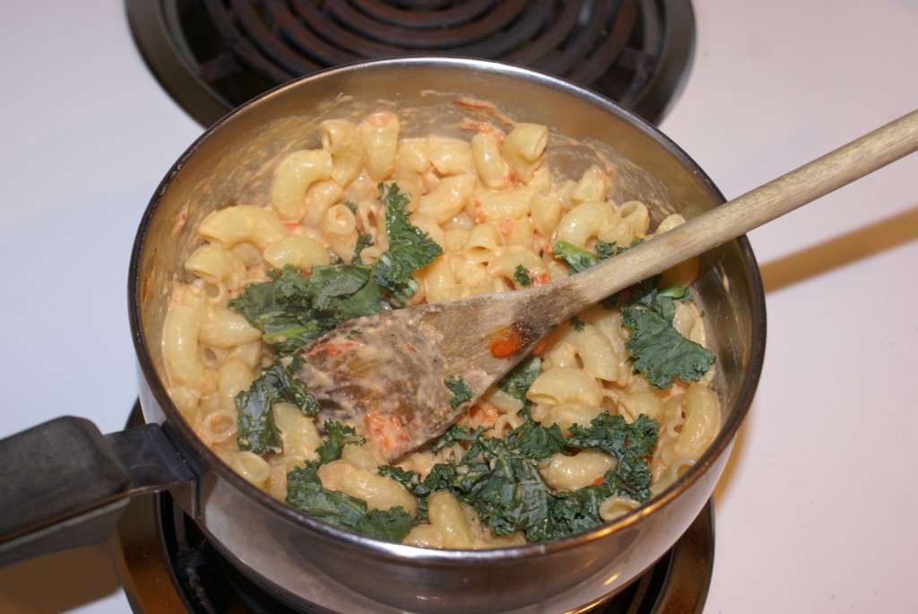 Adding the kale to the mac'n'cheese Adding the kale to the mac'n'cheese.