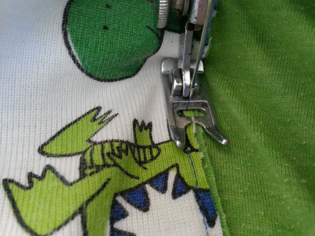 Fold back and straight stitch - through the dino's head again - to get a finished edge. Fold back and straight stitch - through the dino's head again - to get a finished edge.