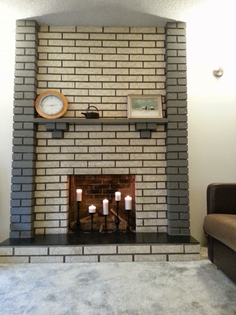 AFTER: Painted grey brick, painted grey wood mantle, gold/brass (broken) doors removed, cleaned and finished slate, lights replaced, candles glowing!
