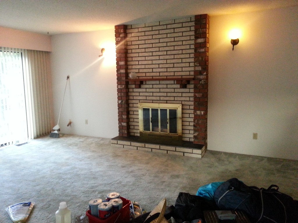BEFORE: Paint-splashed red brick, plus textured cream brick, plus water-stained black slate plus stained wood mantle, plus (broken) gold/brass doors, plus broken light (the one of the left). Charming...not!